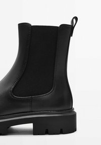 Stivale Chelsea nero in pelle liscia con pannelli laterali elasticizzati. Suola in gomma spessa e texturizzata; linguetta sul retro per una facile vestibilità.