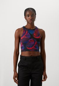 Crop top i lilla og svart, med et rosemønster og mesh-detaljer. Materialet er elastisk med en tettsittende design. Svart høy midje bukser.