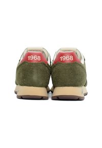 Grüne Wildleder-Sneaker mit beigen Akzenten, mit rotem 1968-Branding an der Ferse und einer beigen Gummisohle. Texturiertes Obermaterial, Rückansicht.