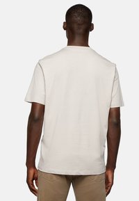 Beige short-sleeve T-shirt made of cotton, featuring a crew neck and a relaxed fit, with a smooth texture and no visible patterns or accents.