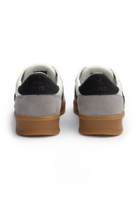 Lloyd-Sneaker mit weißem Lederobermaterial, grauen Wildledereinsätzen, schwarzem strukturiertem Fersenbereich und einer Gummisohle in Kautschukoptik. Mit geprägtem Logo auf der Ferse.