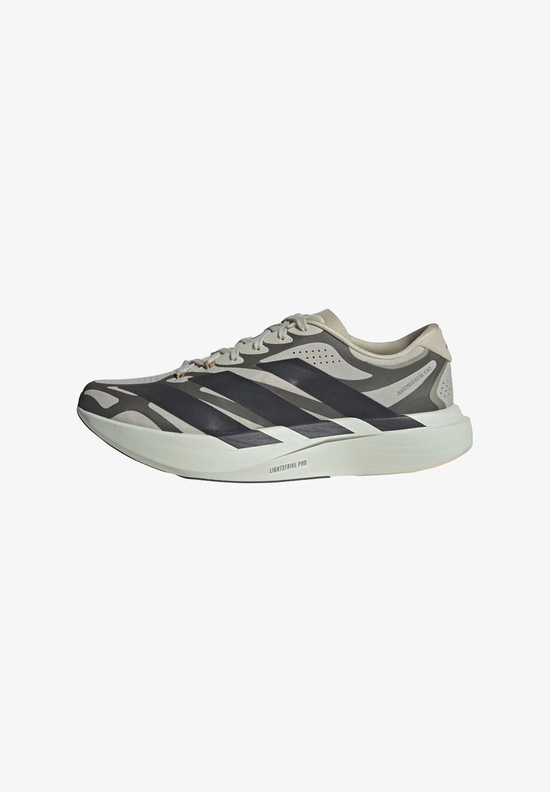 Lys grå og svart løpesko med lisser, tykk hvit såle merket "Lightstrike Pro" og mønstret sidestruktur.