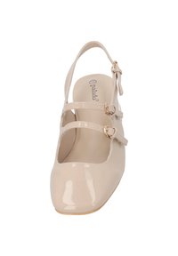 Beige lackläder Mary Jane-sko med två justerbara remmar och rund tå. Slät yta och en tunn ankelsnodd med gyllene detaljer.