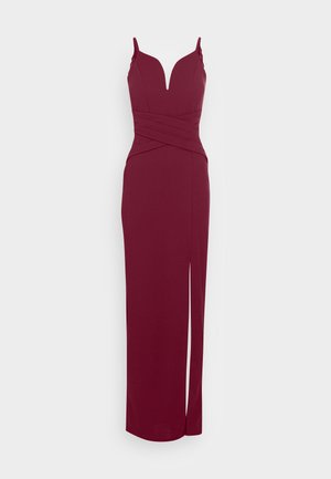 Burgundy evening dress with a deep V-neckline, adjustable straps, and side slit. Textured fabric with a fitted silhouette and cross-over design.