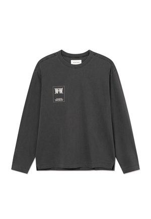 Ciemnoszara koszula z długim rękawem i okrągłym dekoltem, z małym białym nadrukiem i tekstem po lewej stronie klatki piersiowej.