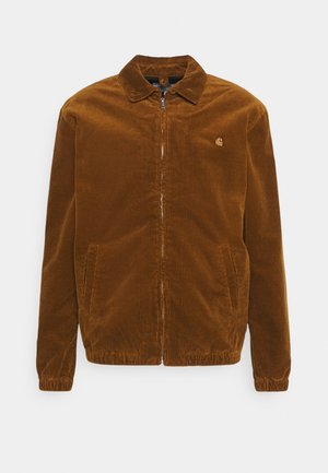 Brązowa kurtka sztruksowa na zamek z kołnierzem, elastycznymi mankietami, bocznymi kieszeniami i małym logiem na lewej piersi.