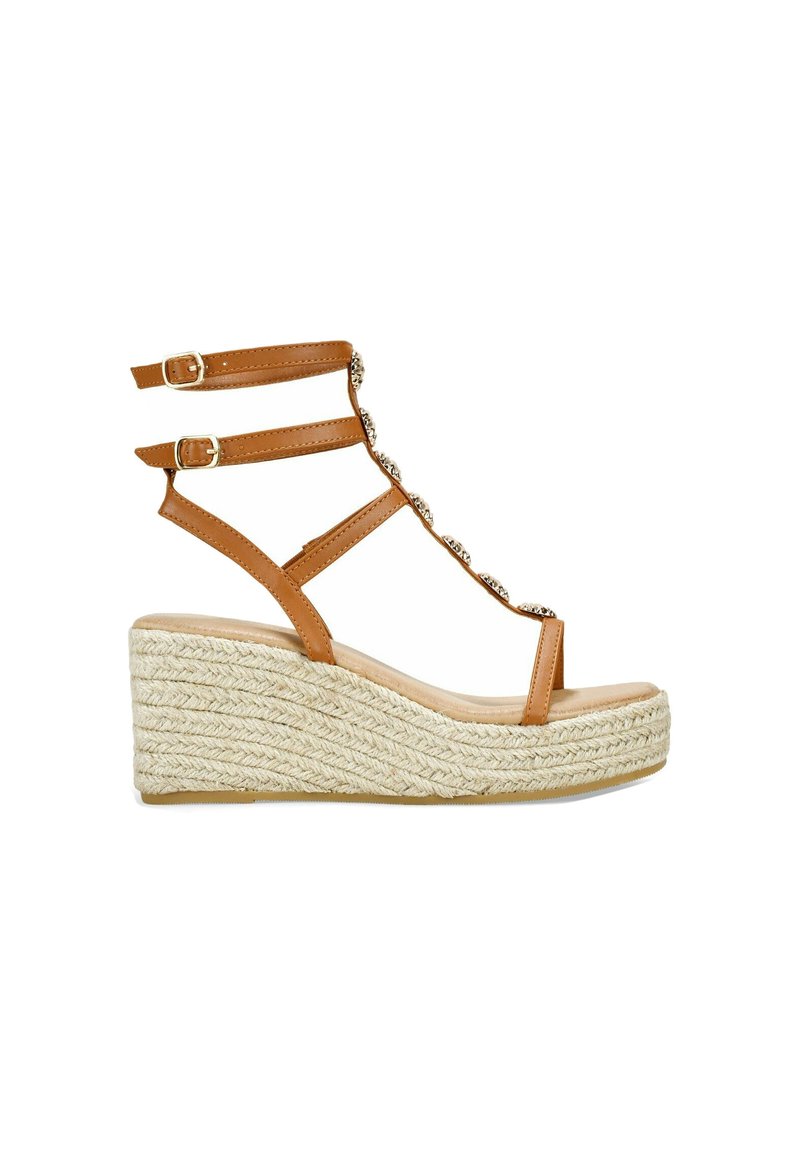Sandalias de cuña con tiras marrones y suela de yute trenzado. Presenta dos hebillas ajustables y un detalle decorativo de cadena en las tiras.