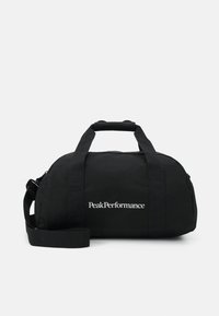 Bolsa de viaje negra hecha de tela resistente, con dos asas robustas, una correa de hombro desmontable y un logotipo blanco en la parte frontal.