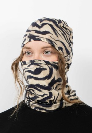 Beige Kopfbedeckung mit einem schwarzen abstrakten Tiger-Muster, mit einer enganliegenden Form, die Kopf und Hals bedeckt, aus weichem Stoff gefertigt.