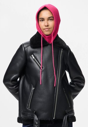 Black leather jacket with zippers and a fur collar, paired with a bright pink hood. The jacket features a boxy design and soft texture.