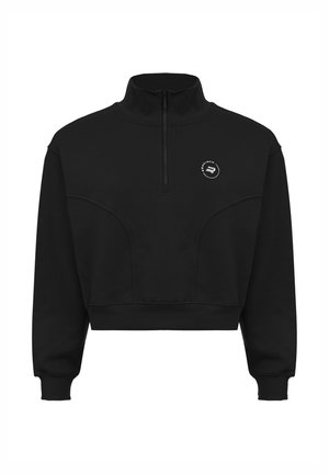 Sudadera negra corta con cuello alto, cremallera parcial y detalle de logo blanco en el pecho. Textura suave y diseño deportivo.
