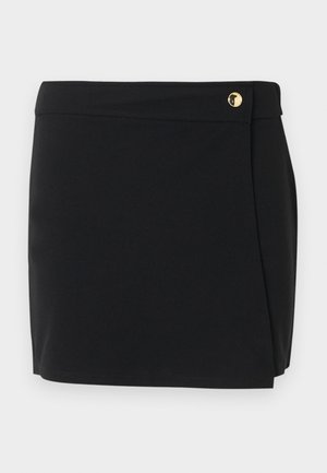 Μίνι μαύρη φούστα με σχεδιασμό τύπου wrap και μικρή χρυσή λεπτομέρεια κουμπιού στη μέση.