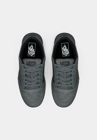 Sneakers Vans grigi con tomaia in suede morbido, punta perforata, lacci piatti e collare imbottito. Presentano un logo nero sulla linguetta.