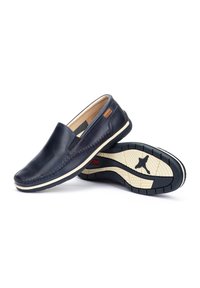 Zapatos de charol azul marino sin cordones con un diseño cosido, paneles laterales elásticos y una suela de goma texturizada con un acento de color claro.