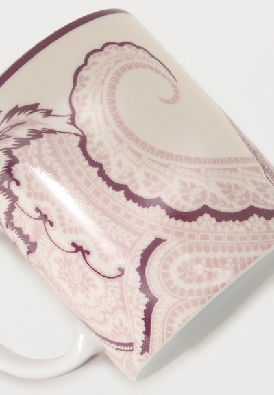 Tasse en céramique blanche avec un motif cachemire détaillé rose et bordeaux et une anse blanche unie sur fond blanc.
