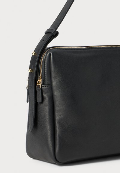 Borsa a tracolla in pelle nera con una superficie liscia, dotata di zip e accessori in oro. Forma rettangolare e tracolla regolabile.