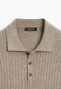 Beige ribbed knit polo shirt with spread collar and three black buttons, labeled Massimo Dutti.