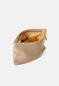 Béžová taštička s korálky, texturovaným povrchem, zlatým zipem a hladkým saténovým vnitřkem s malou kapsou.