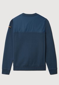 Marineblå sweatshirt med en glat, blank øverste del og ribstrikkede manchetter. Har et lille logopatch på venstre ærme.