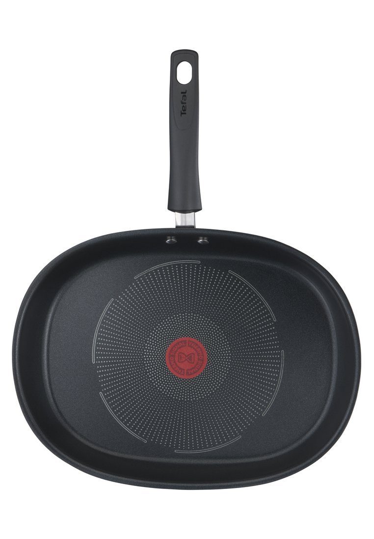 Czarna prostokątna patelnia nieprzywierająca z teksturowaną powierzchnią i czerwonym wskaźnikiem ciepła w centrum. Posiada solidny czarny uchwyt.