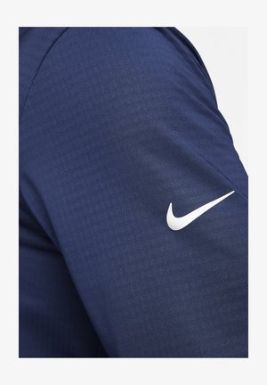Jūrinė sportinė marška su tekstūruota medžiaga, matoma ryški balta Nike logotipas kairėje peties srityje.