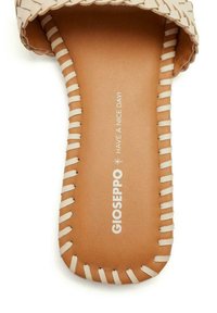 Sandale glissante à upper tissé beige avec une semelle plate en cuir marron, des coutures détaillées et un logo imprimé disant "GIOSEPPO HAVE A NICE DAY !"