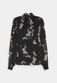 Blouse noire transparente à manches longues, col rond, motif floral en blanc et beige, poignets froncés, matière légère.