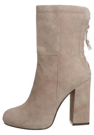 Beige suede ankle boot with a stacked heel, smooth texture, side lacing detail, and rounded toe. Stylish yet simple design.