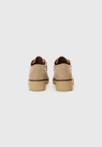 Helle Wildlederschuhe mit abgerundeter Zehenpartie und niedrigem Blockabsatz. Das schlichte Design bietet minimale Nähte und keine sichtbaren Beschläge.
