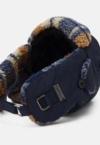 Marineblauwe hoed met een pluche, veelkleurige fleece voering en een doorstikte buitenkant. Voorzien van een metalen gesp en merklabel-details.