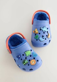 Blue clogs with a textured surface, featuring colorful animal-themed decorations. Plush lining and an orange strap enhance comfort and fit.