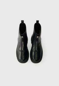 Melnas ādas potītes zābaki ar priekšējo rāvējslēdzēju, apaļu purngalu un teksturētu zoli. Piederums mugurpusei nodrošina vieglu uzvilkšanu.