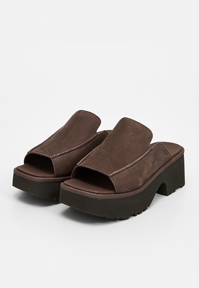 Sandalias de plataforma de cuero marrón con punta abierta y superficie texturizada. Cuentan con una correa ancha y una suela de goma gruesa para mayor estabilidad.