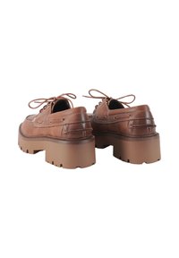 Scarpe platform in pelle marrone con punta arrotondata, lacci e dettagli cuciti. Suola beige spessa e strutturata con motivi intagliati.