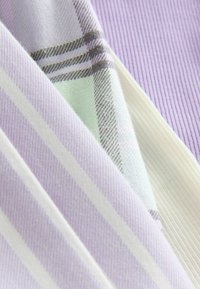 Tekstiler med lavendel- og hvide striber samt et mintgrønt plaid-design, der viser glatte og ribbede teksturer.