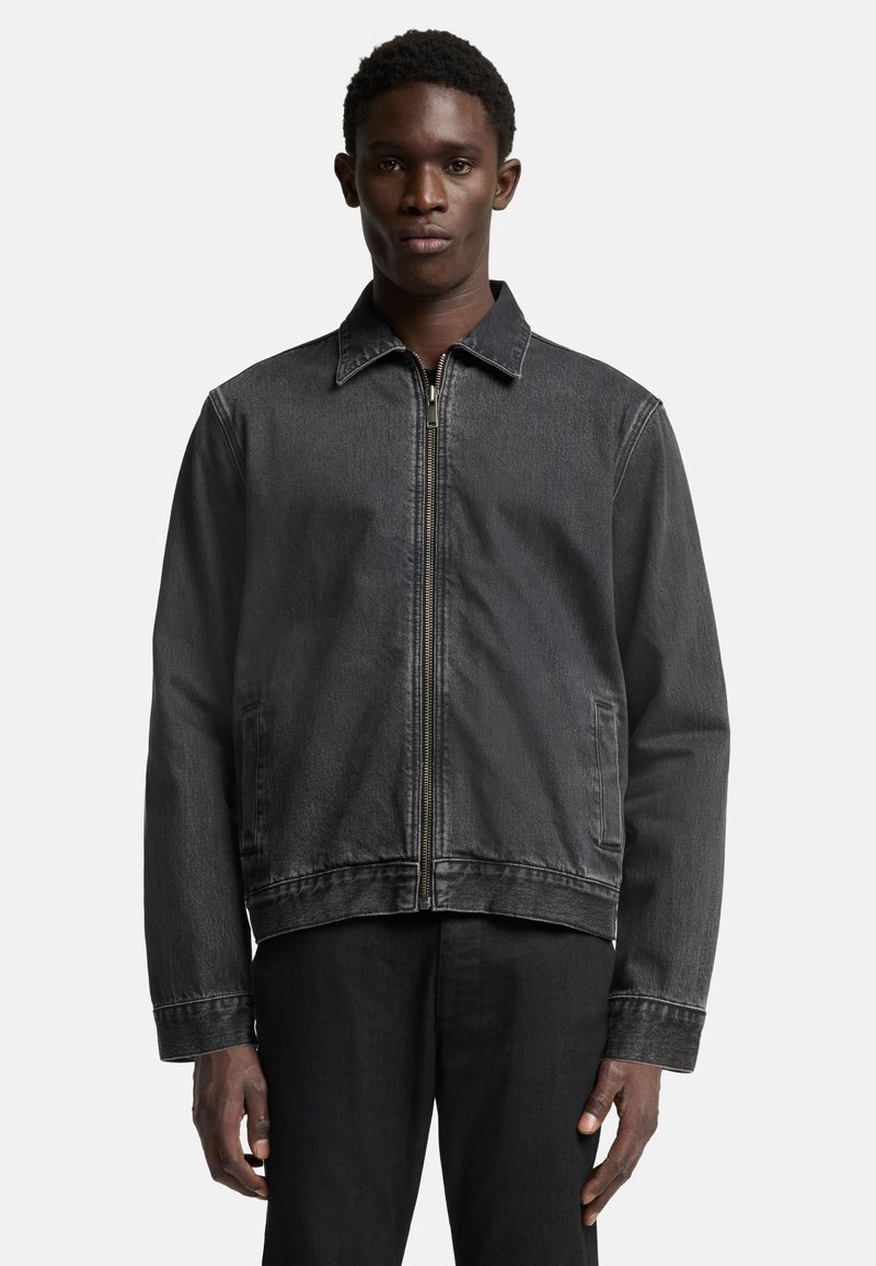 Svart denimjacka med dragkedja fram, spetskrage och två sidfickor. Tyget har en lätt textur och en klassisk passform.