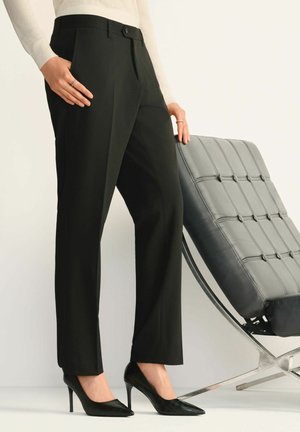 Czarne dopasowane spodnie o prostej nogawce, z bocznymi kieszeniami i gładkim wykończeniem. Noszone z czarnymi szpilkami w szpic.
