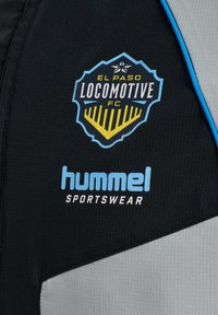 El Paso Locomotive FC-logo en Hummel Sportswear-branding op zwarte en grijze sportstof met blauwe biezen.