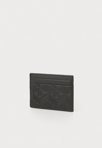 Carte en cuir noir avec des motifs géométriques en relief et un logo. Design fin avec des fentes pour cartes de chaque côté.