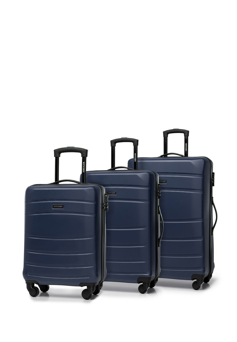 Tre valigie rigide blu di diverse dimensioni, con un design testurizzato, manici neri e ruote scorrevoli.