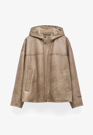 Giacca a cappuccio beige con una texture morbida, dotata di due tasche frontali, chiusura con bottoni a pressione e cuciture scure a contrasto lungo i bordi.