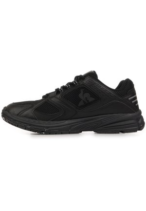 Sneaker atletica nera con pannelli in mesh, design con lacci, suola imbottita e logo discreto sul lato, vista dal lato esterno.