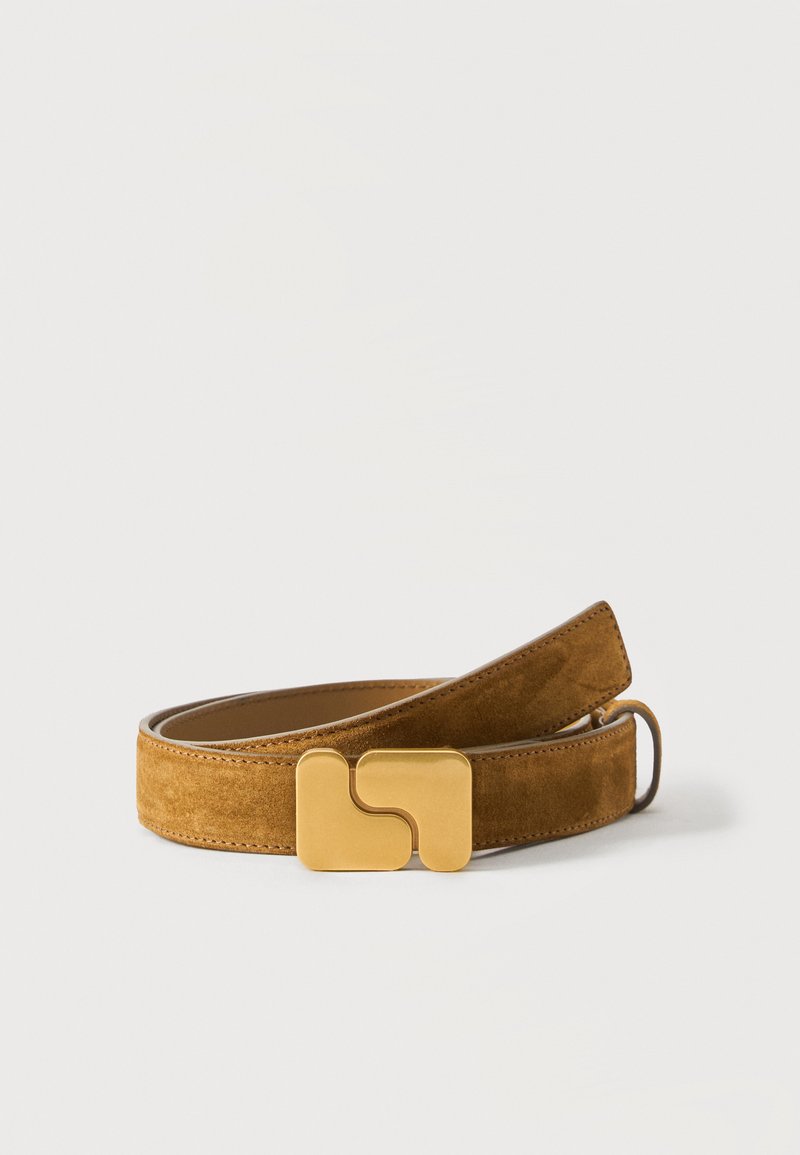 Ceinture en daim marron avec une grande boucle dorée géométrique, enroulée sur un fond blanc.