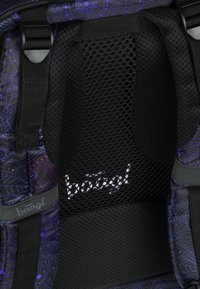 Zaino con pannello posteriore in rete nera, tessuto a motivo viola, spallacci regolabili e logo visibile in bianco. Design texture e resistente.