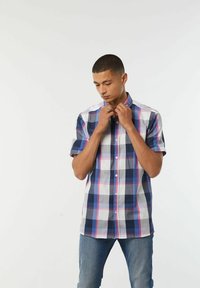Korte mouwen, knoopshirts in een ruitpatroon met marineblauw, wit en roze kleuren. Heeft een klassieke kraag en een ontspannen pasvorm.