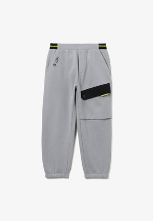 Pantalones de chándal grises con puños elásticos, que cuentan con bolsillos laterales y un bolsillo negro con botón. Incluye el texto "ON SLOPES" en negro.