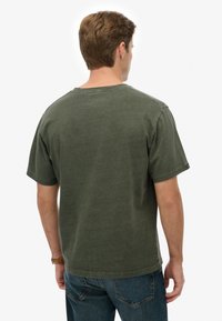 Olivengrøn bomuldst-shirt med afslappet pasform, korte ærmer og rund halsudskæring, med en tekstureret finish.