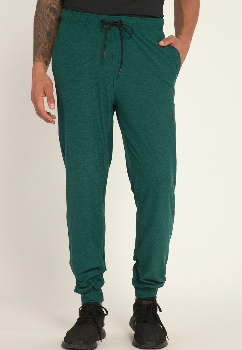 Teal joggingbroek gemaakt van zacht materiaal, met een elastische tailleband met trekkoorden, zijzakken en taps toelopende pijpen.