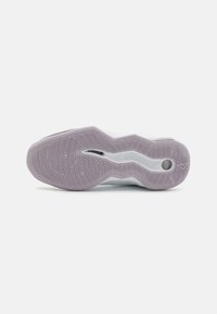 Sula med en lila gummibas med cirkulära och vågmönster, samt en lagerdesign av vit mellansula för dämpning.