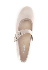 Zapato Mary Jane de ante beige claro con punta redondeada, correa y hebilla ajustable. Forro interior suave, con un detalle de costura mínimo.